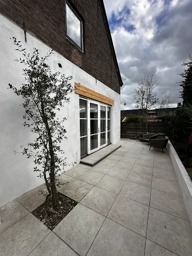 Achtergevel met terras en olijfboompjes