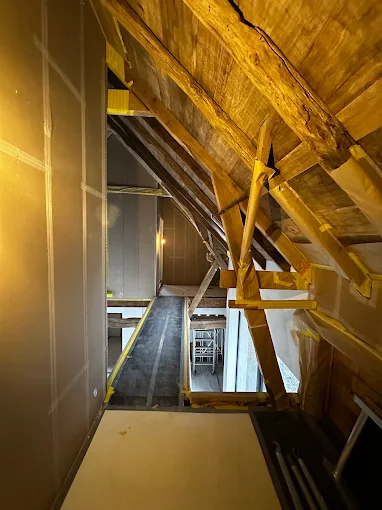 Zolderconstructie met houten balken en ladder