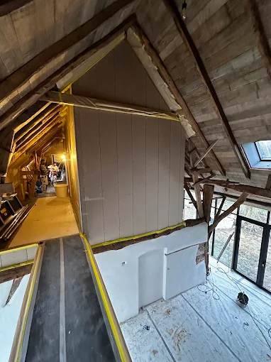Zolder met houten balkenplafond en steiger